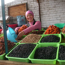 Femme avec ces fruits et nois, marché d’Osh, Kirghizistan